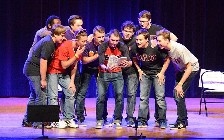 Group of students performing on stage during Greek Sing